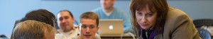 A Professor looking at a student's laptop.