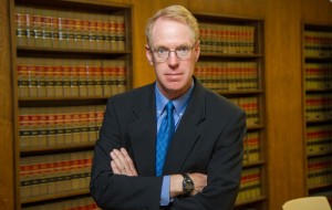 Paul Cassell standing with his arms crossed in the library
