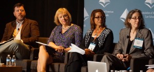 four presenters seated in a row at the Plenary Session on Innovative and Sustainable Clinical Engagement with Community Needs