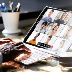 Hand sitting on laptop keyboard with zoom sdreen