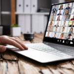 Hand sitting on laptop keyboard with zoom sdreen