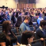 Crowd shot of a standing audience at a conference