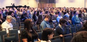 Crowd shot of a standing audience at a conference