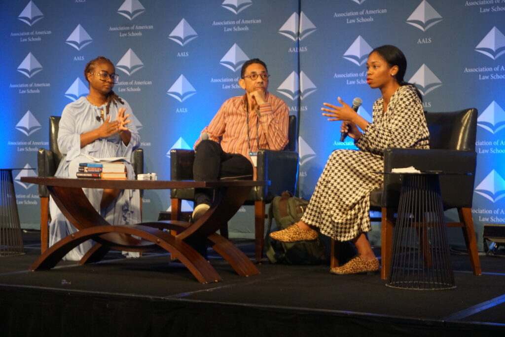 Panel of three talking on stage