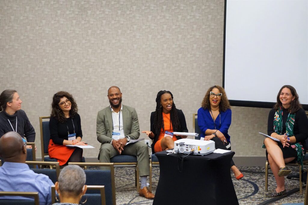 Clinical faculty sit smiling in professional dress at the 2023 Clinical Conference