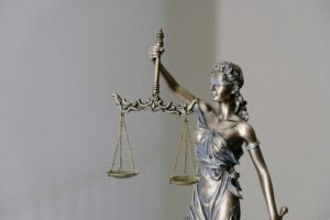 A statute of lady justice holds scales while blindfolded